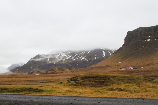 Free photo landscape of hills covered in the snow and grass under a cloudy sky in iceland