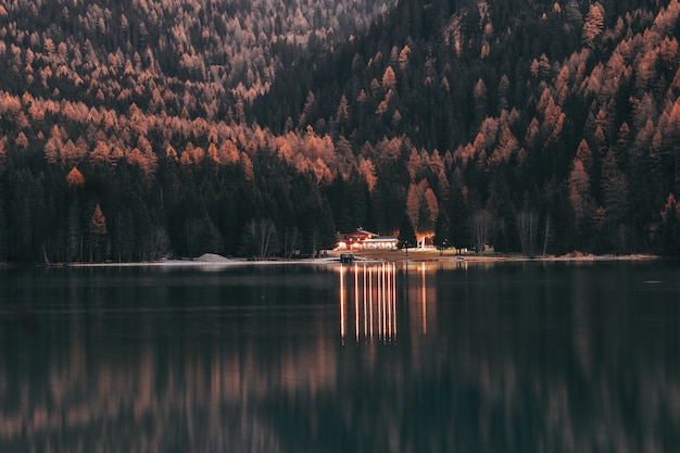 Landscape Of House Near Woods And Calm Body Of Water