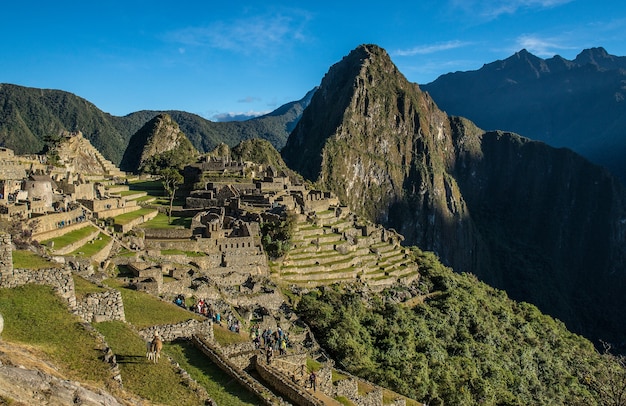 Free photo landscape of machu picchu under the sunlight and a blue sky in peru