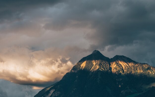 Landscape of rocks covered in the forests under the sunlight and a cloudy sky