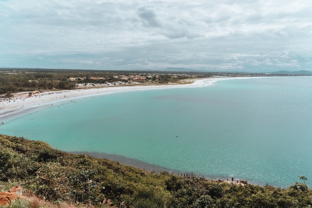 Free Photo landscape of the sea surrounded by an island covered in the greenery under a cloudy sky