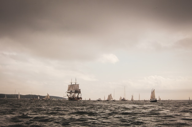 Free Photo landscape of the sea with sailing ships on it under a cloudy sky in the evening