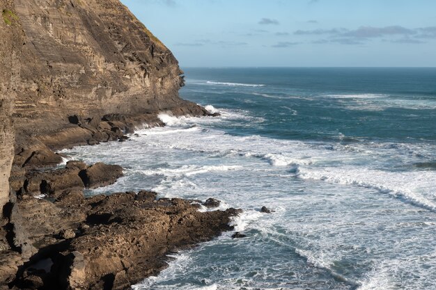 Landscape shot of a breathtaking rocky coast with cliffs and angry waves