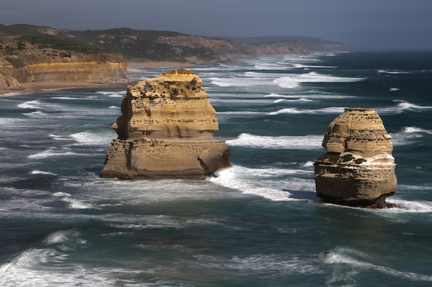 Landscape shot of rocks in a body of water near the shore.