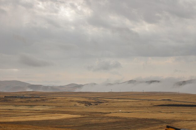 Landscape surrounded by high mountains under the storm clouds