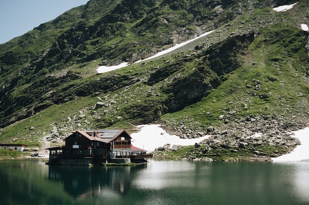 Free Photo landscape view of balea lake in romania and fagaras mountains in the summer with snowy peaks