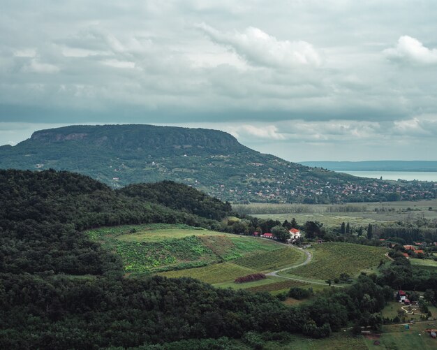 Landscape view of the fields and hills on shore of a lake on cloudy day