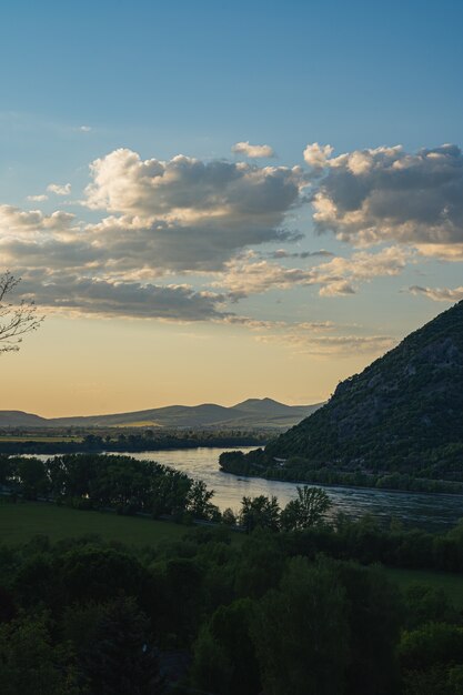 Landscape view of the hills on the shore of a calm lake under the blue sky