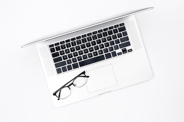 Free photo laptop and glasses on a white background top view