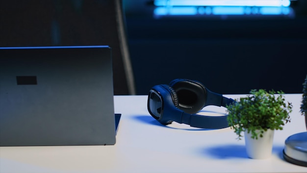 Free Photo laptop headphones and mini house plants on table in apartment room