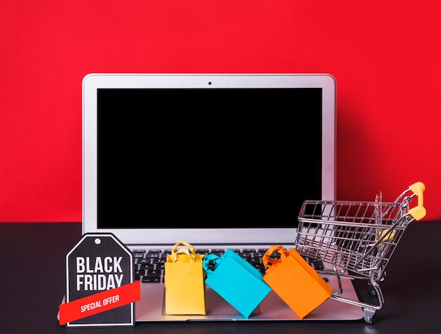 Laptop near toy bags, sign and supermarket cart