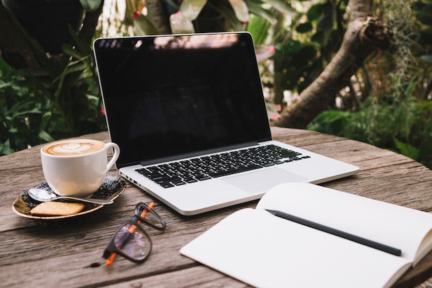 Free Photo laptop and notebook on timber table