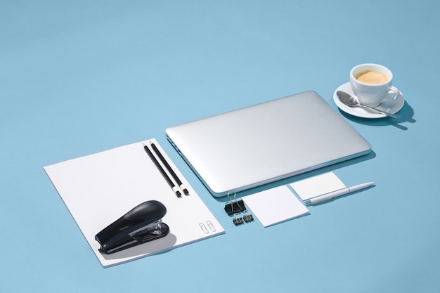 The laptop, pens, phone, note with blank screen on table