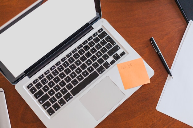 Laptop sheets and pen placed on table