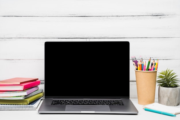 Laptop surrounded by office supplies