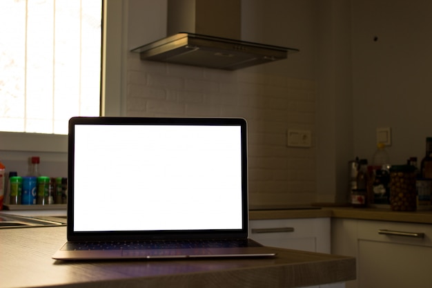 Free photo laptop with blank screen in the kitchen