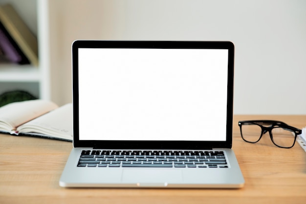 Laptop with blank screen on wooden desk