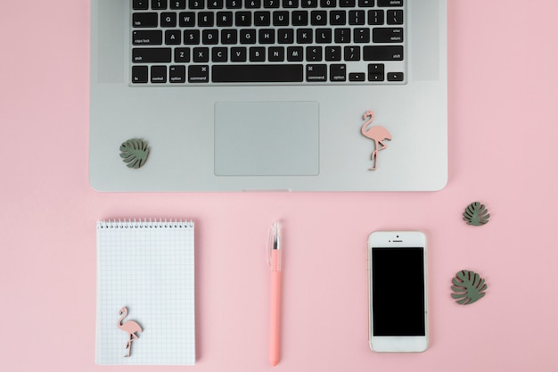 Laptop with smartphone and small flamingos 