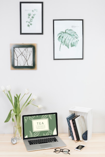 Free photo laptop with tulips in vase on table