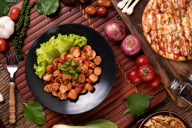 Larb Sausage with Chili Spring onions and lettuce in a black plate