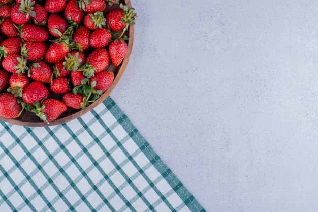 Large bowl full of strawberries on marble background. High quality photo