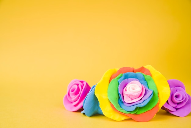 Free Photo large creative beautiful rose made with clay on yellow background