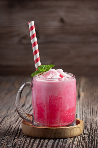 Free photo large glass of strawberry milkshake with colorful straws