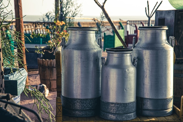 Free photo large old metal milk cans in the beautiful setting of the sun