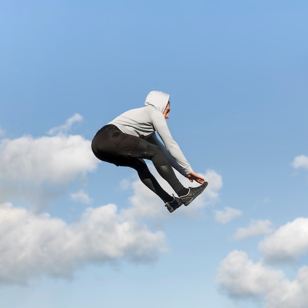 Free photo lateral view athletic man jumping