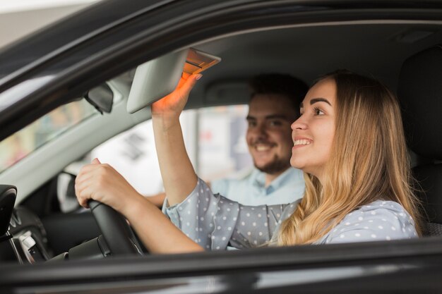 Lateral view beautiful blonde woman in car