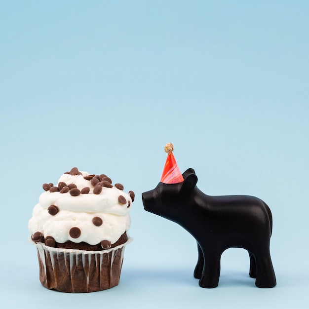 Free photo lateral view tasty muffin and chocolate pig