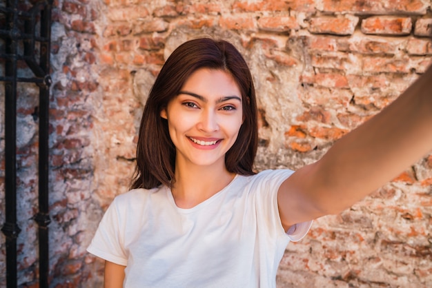 Free Photo latin woman taking a selfie.