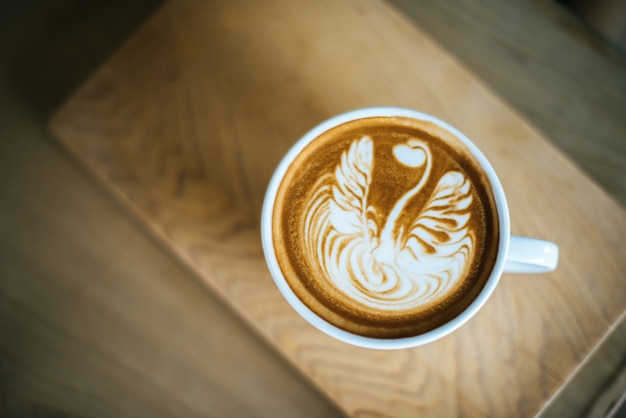 Latte art in coffee cup on the cafe table