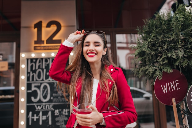 Laughing adorable girl in red jacket walking around street