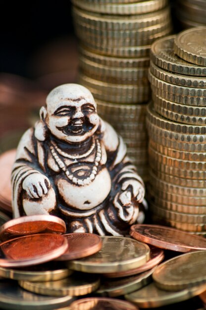 Laughing Budda in front of coins