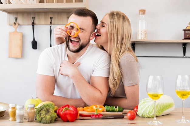 Free Photo laughing couple playing with bell pepper