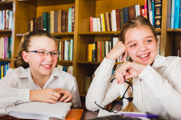 Laughing cute girls sitting with copybooks 