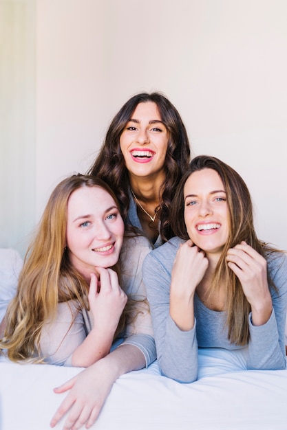 Laughing friends on bed