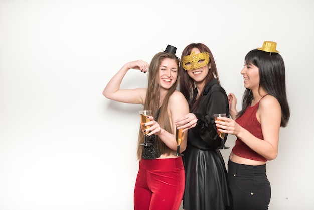 Laughing ladies in evening wear with glasses of drinks