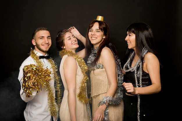 Free photo laughing ladies and guy in evening cloths with tinsel