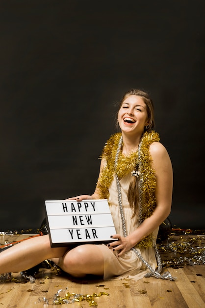 Free photo laughing lady in evening wear with tablet on floor