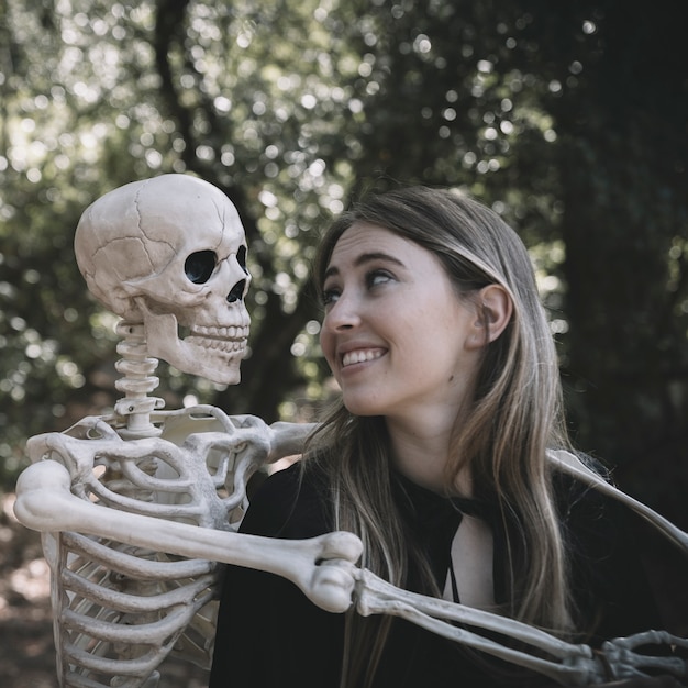 Free photo laughing lady looking at skeleton