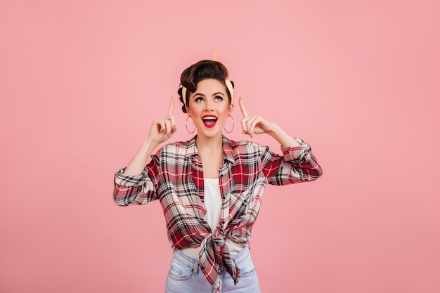 Free photo laughing pinup girl looking up. studio shot of emotional young lady in checkered shirt.