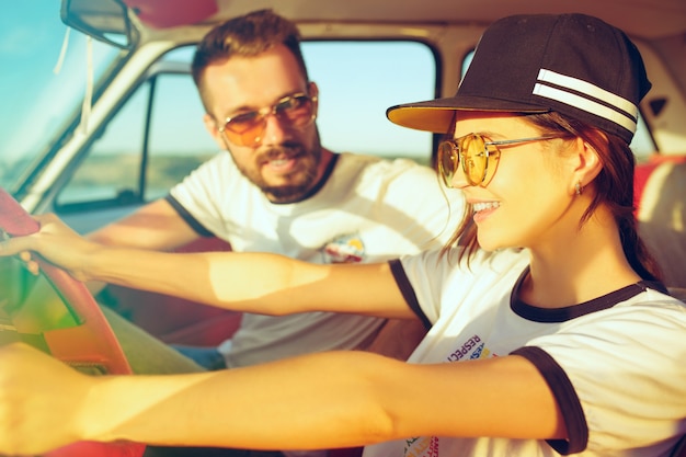 Free photo laughing romantic couple sitting in the car while out on a road trip