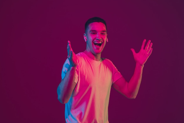 Laughing, shocked. Caucasian man's portrait isolated on pink-purple studio wall.