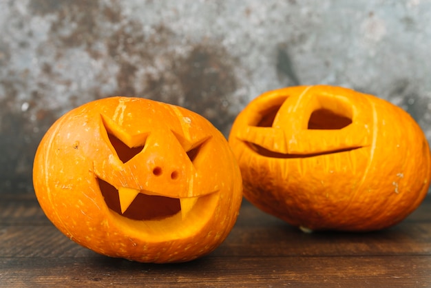 Free Photo laughing and smiling carved halloween pumpkins on desk