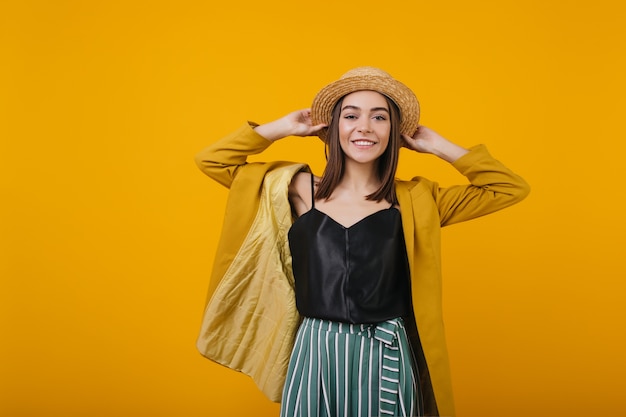 Free photo laughing winsome woman in straw hat posing. attractive lady in black tank-top isolated.