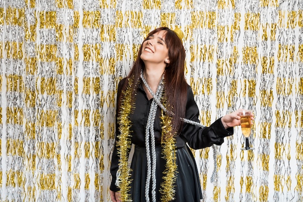 Laughing woman in evening wear with glass of drink