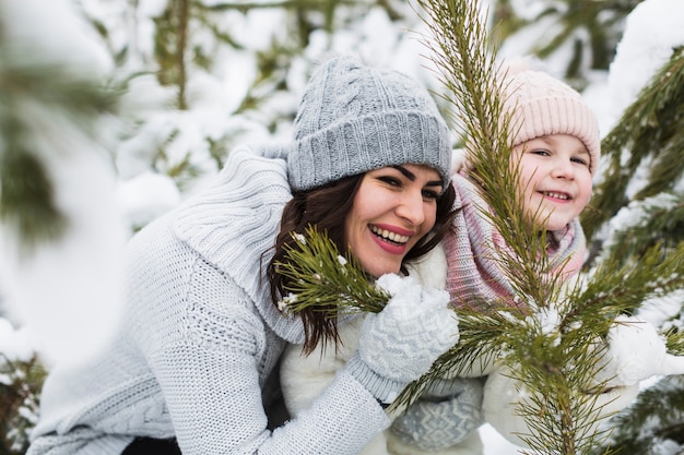 Laughing woman and girl near spruce