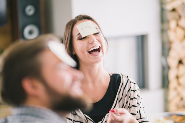 Laughing woman playing game with friends